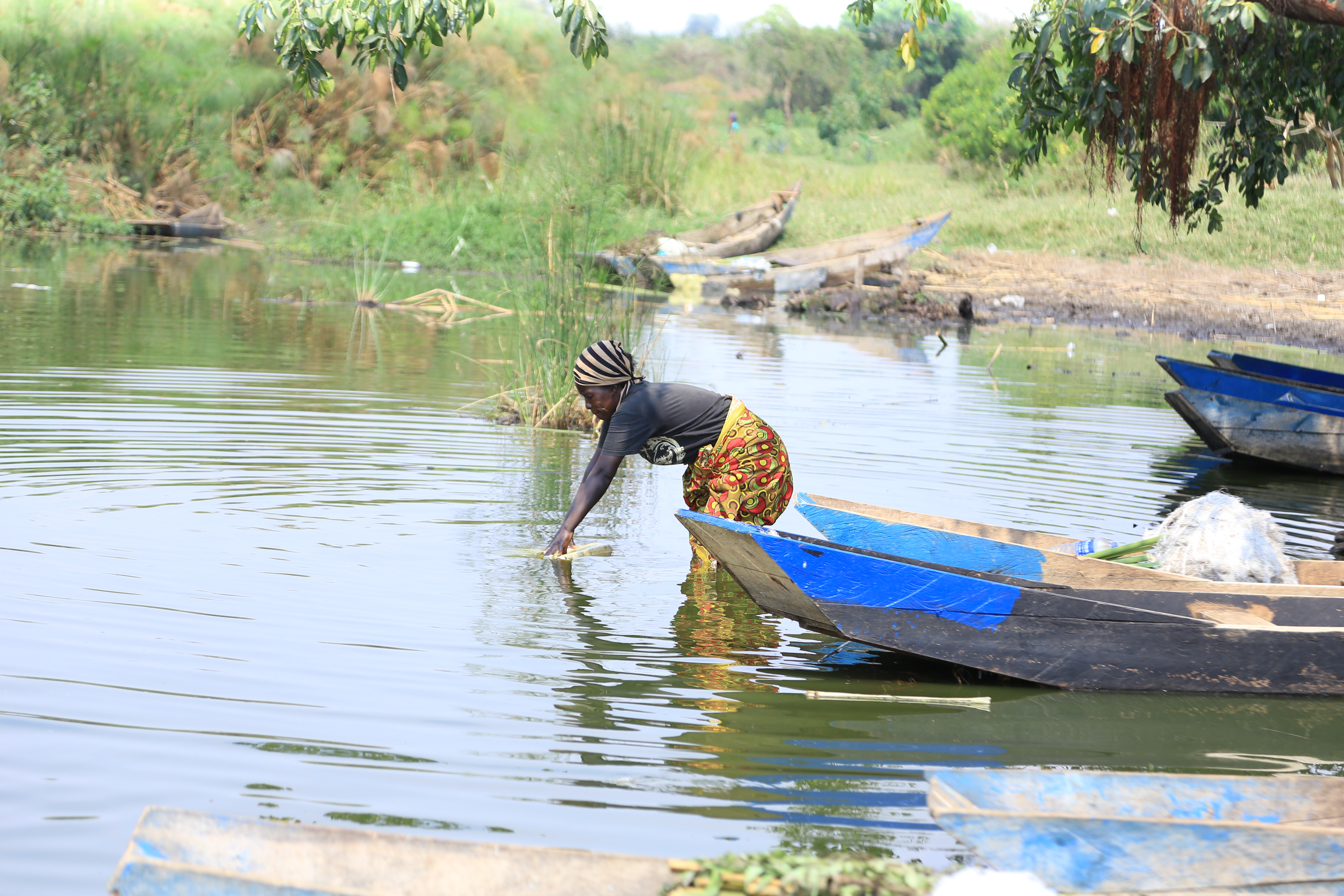 A woman collects water for domestic use at oneof the fishiong grounds along Lake Nakivale